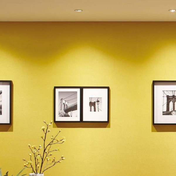 parede amarela com quadros decorativos e uma boa iluminação