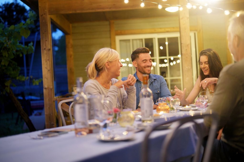 pessoas reunidas numa área gourmet externa com iluminação criativa e funcional