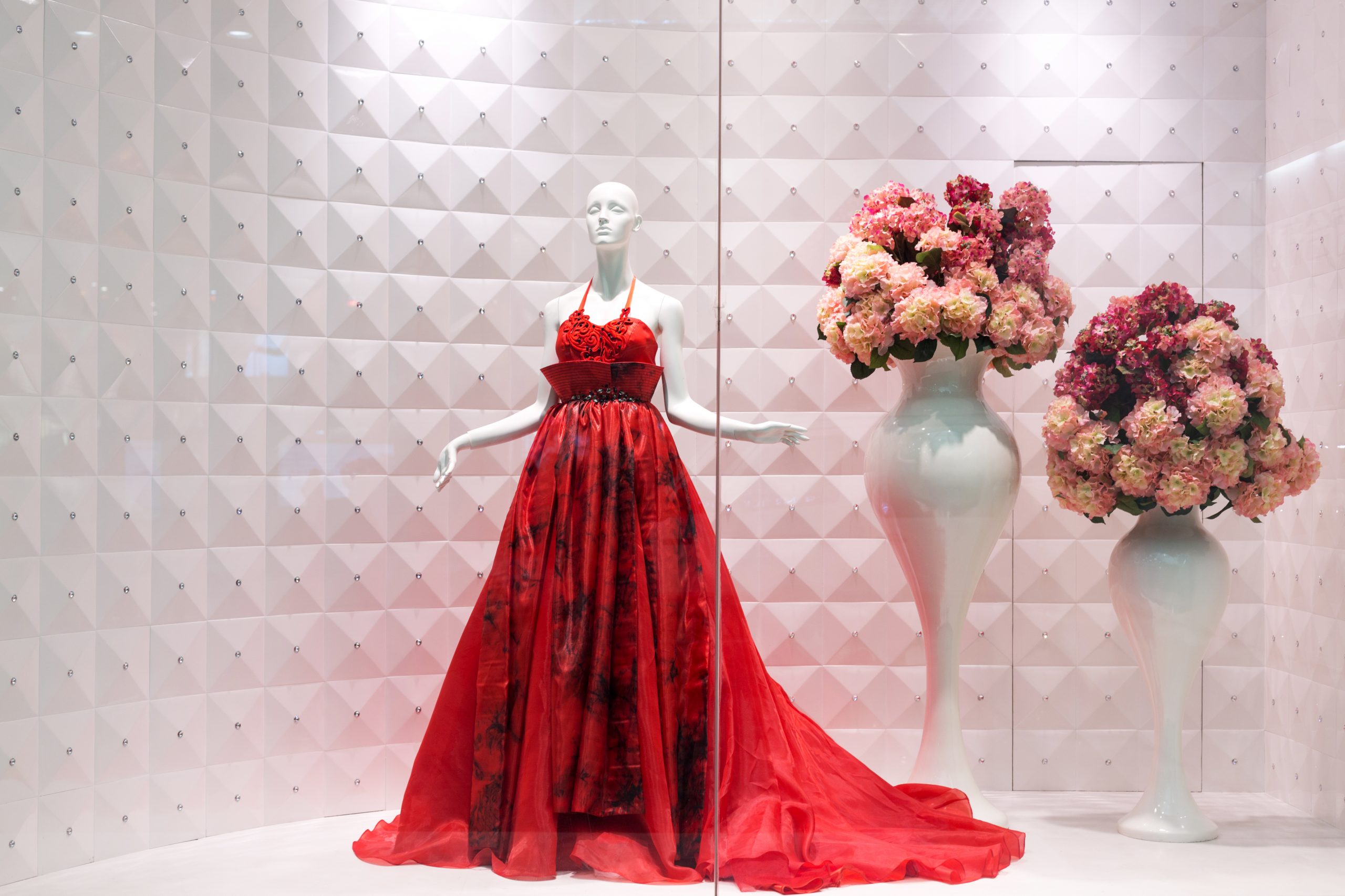 Vitrine de uma loja de roupas com um vestido vermelho com uma iluminação de destaque com alto IRC